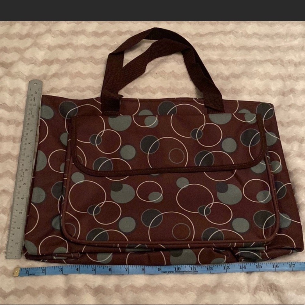 New brown tote. Open on inside. Side netted pockets. Front Velcro close pocket